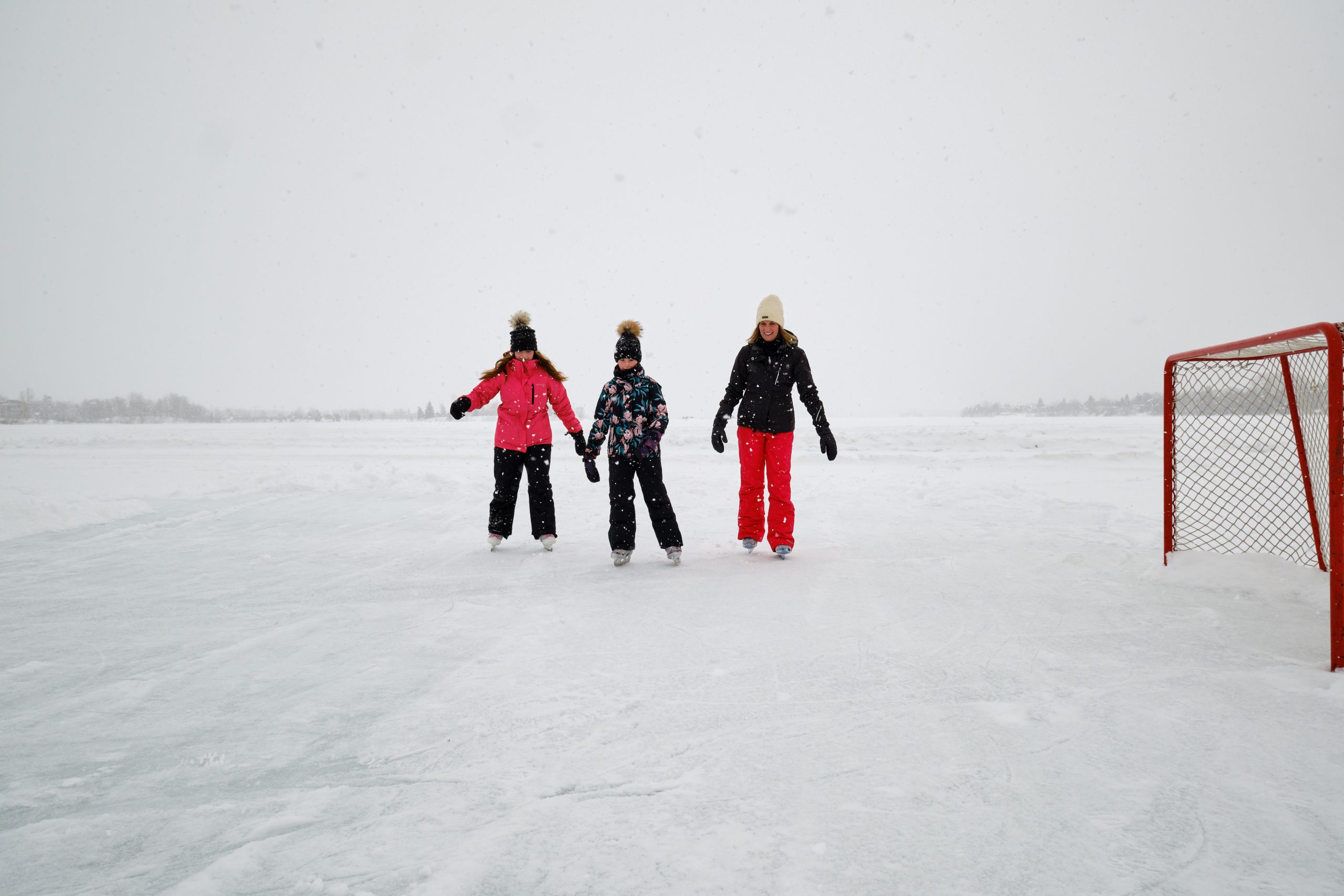 Une mère et ses deux filles font du patin sur le rond de glace du lac Osisko à Rouyn-Noranda